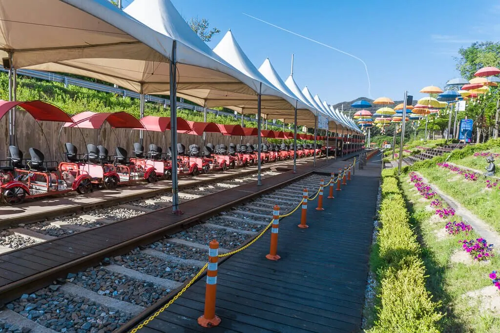 Rows of red railbikes ready beneath white canopies at Kim You-jeong Station in Gapyeong