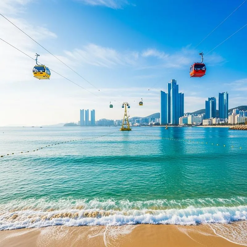 Colourful red and yellow cable cars gliding over Songdo Beach's clear blue water on a sunny day