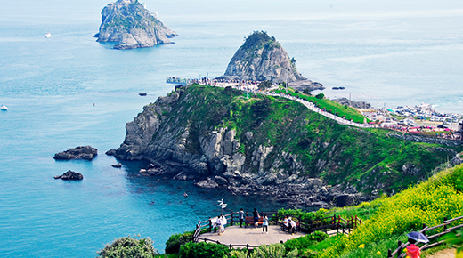 Green headland and rocky Oryukdo islands in turquoise water