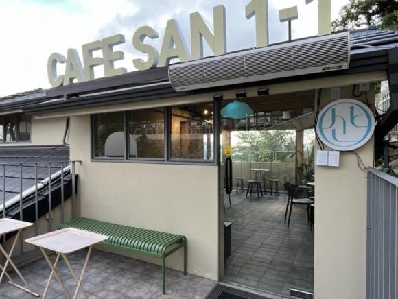 Entrance of Cafe San 1-1 with outdoor tables on a rooftop terrace in Ihwa-dong, Seoul