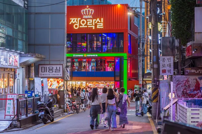 Street performers and neon signs in Hongdae, Seoul at night