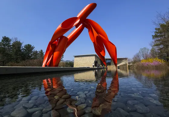 Bright red Archway sculpture reflected in the water garden at Museum SAN in Wonju