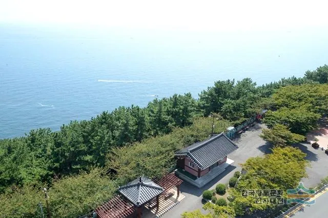 Traditional pavilion and pine trees overlooking the blue sea at Dalmaji Park in Busan