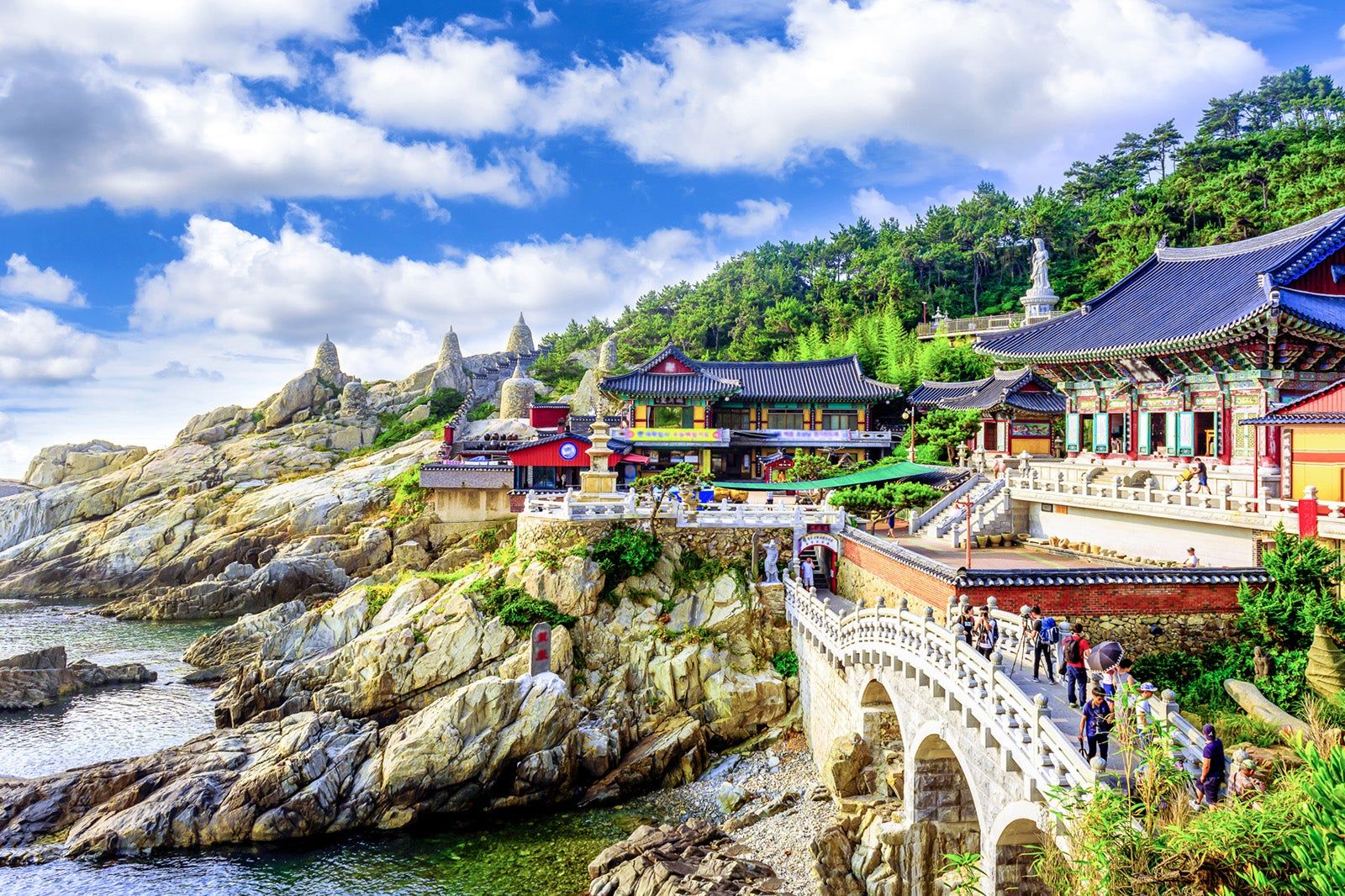 Haedong Yonggungsa Temple overlooking the rocky coastline beneath a bright blue sky