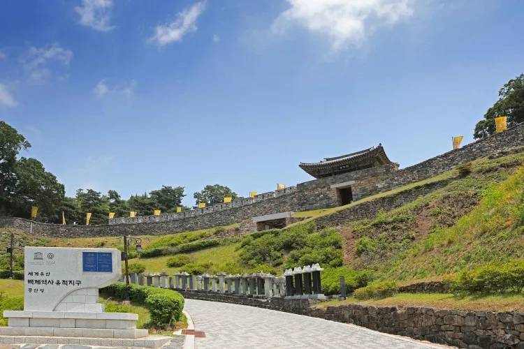 Sunny approach to Gongsanseong Fortress with its stone wall climbing the green hillside