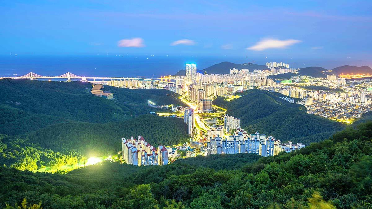 Panoramic night view of Busan's illuminated city, Gwangan Bridge and the coastline seen from Hwangnyeongsan