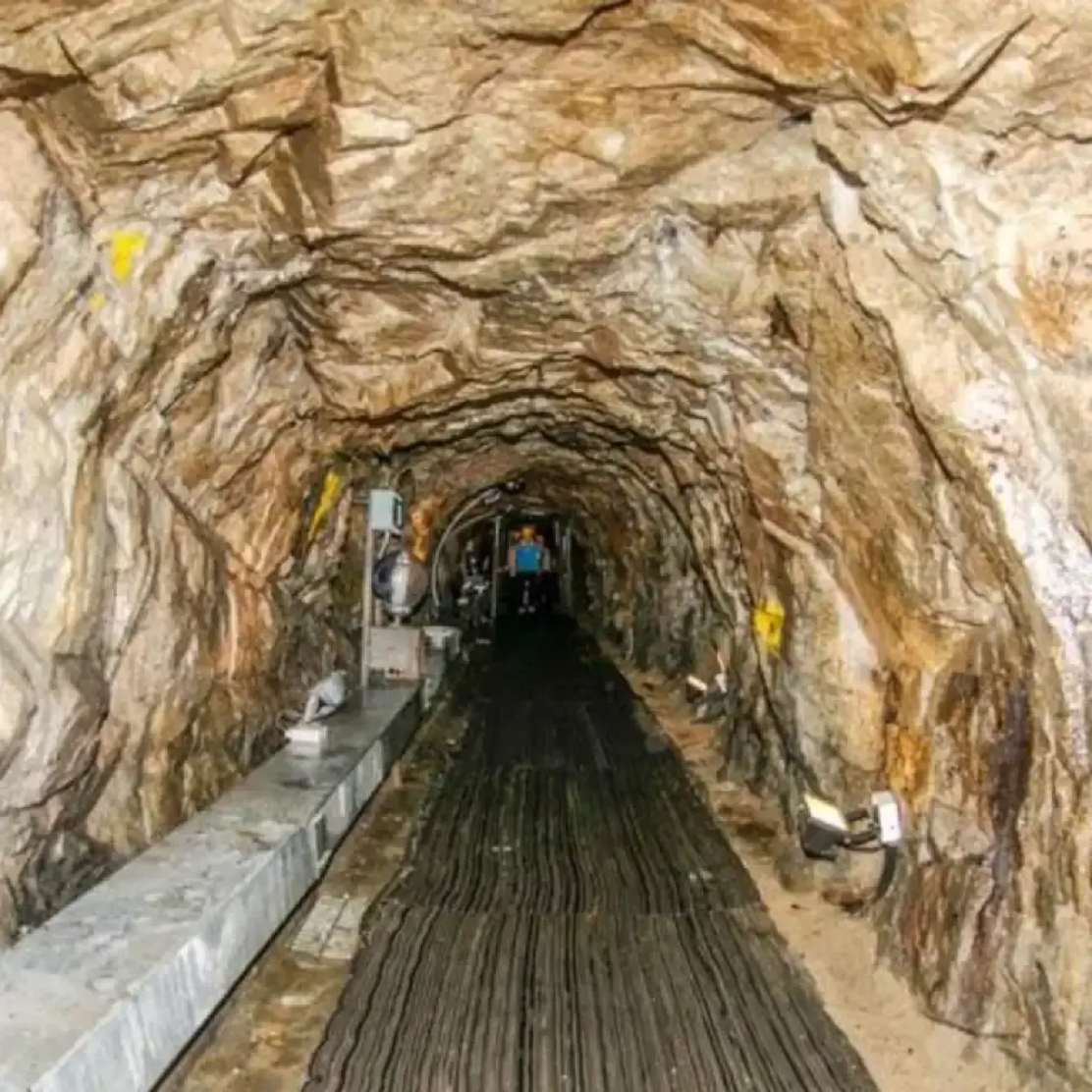 Interior of the Third Infiltration Tunnel with lit rock walls and a sloping walkway