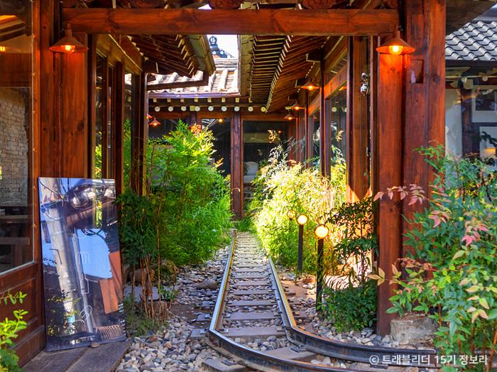 Lantern-lit hanok cafe alley in Ikseondong with an old rail track underfoot