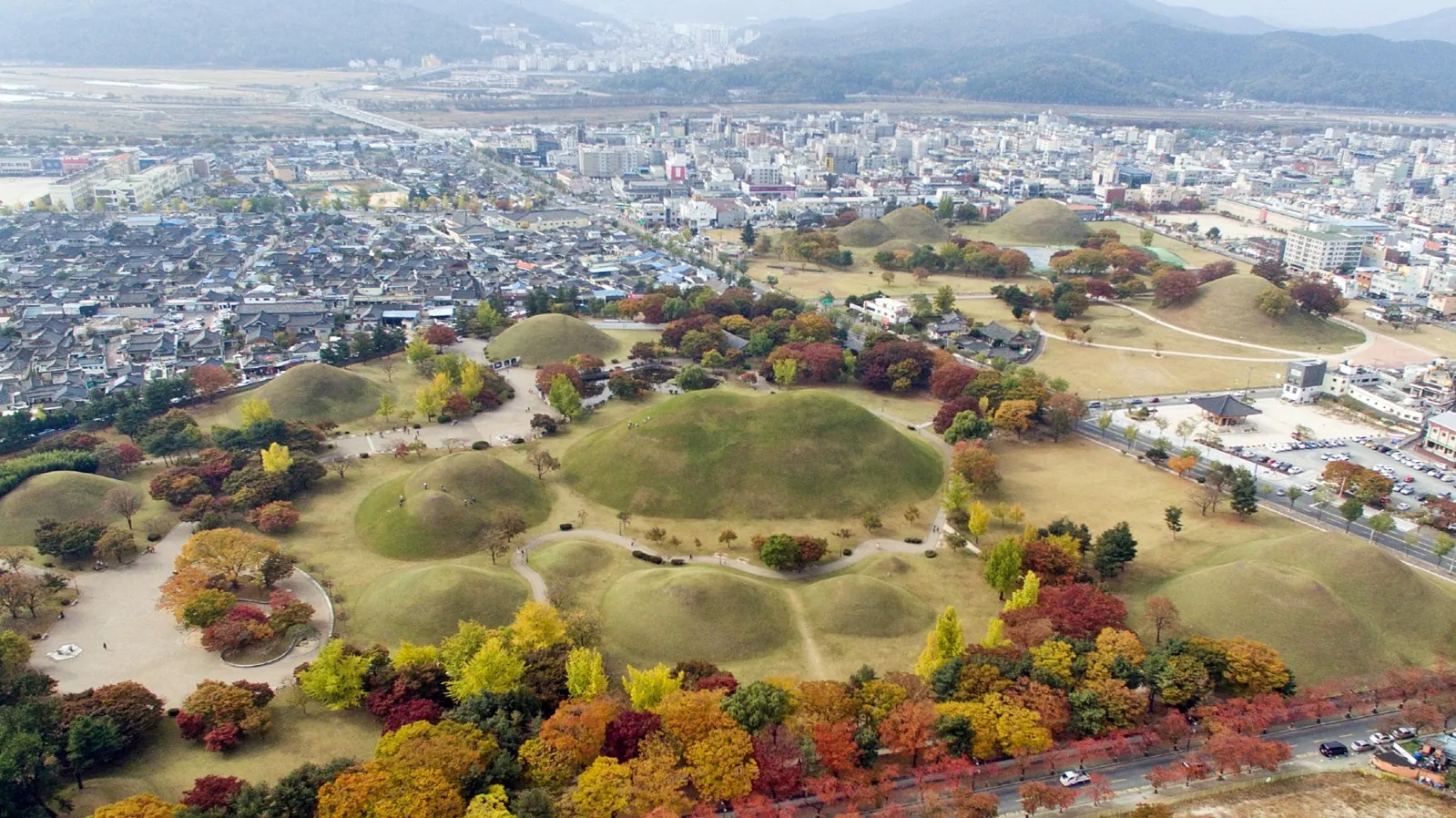 Aerial view of the Daereungwon royal burial mounds surrounded by autumn foliage in Gyeongju