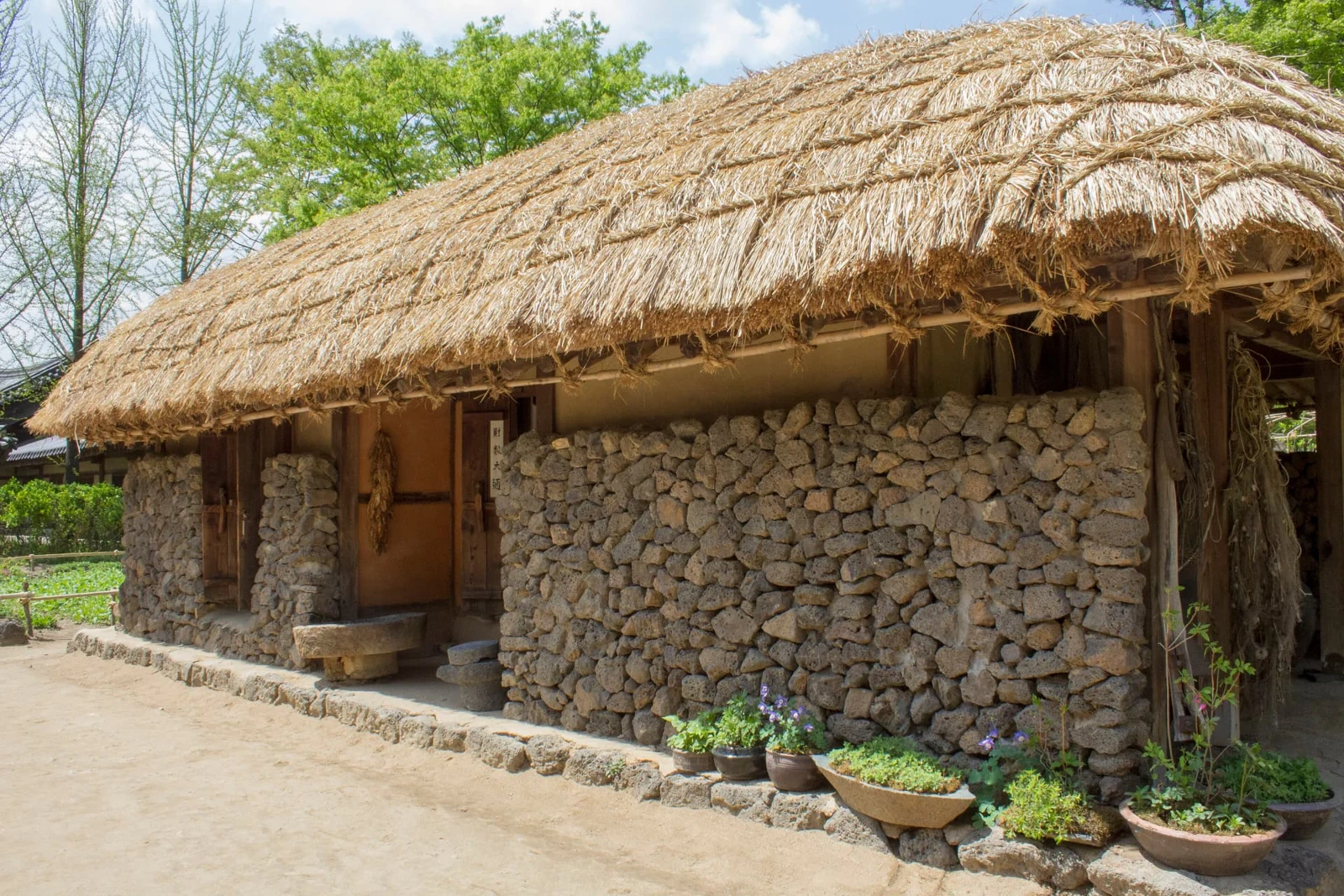Stone-walled traditional house with a thatched roof