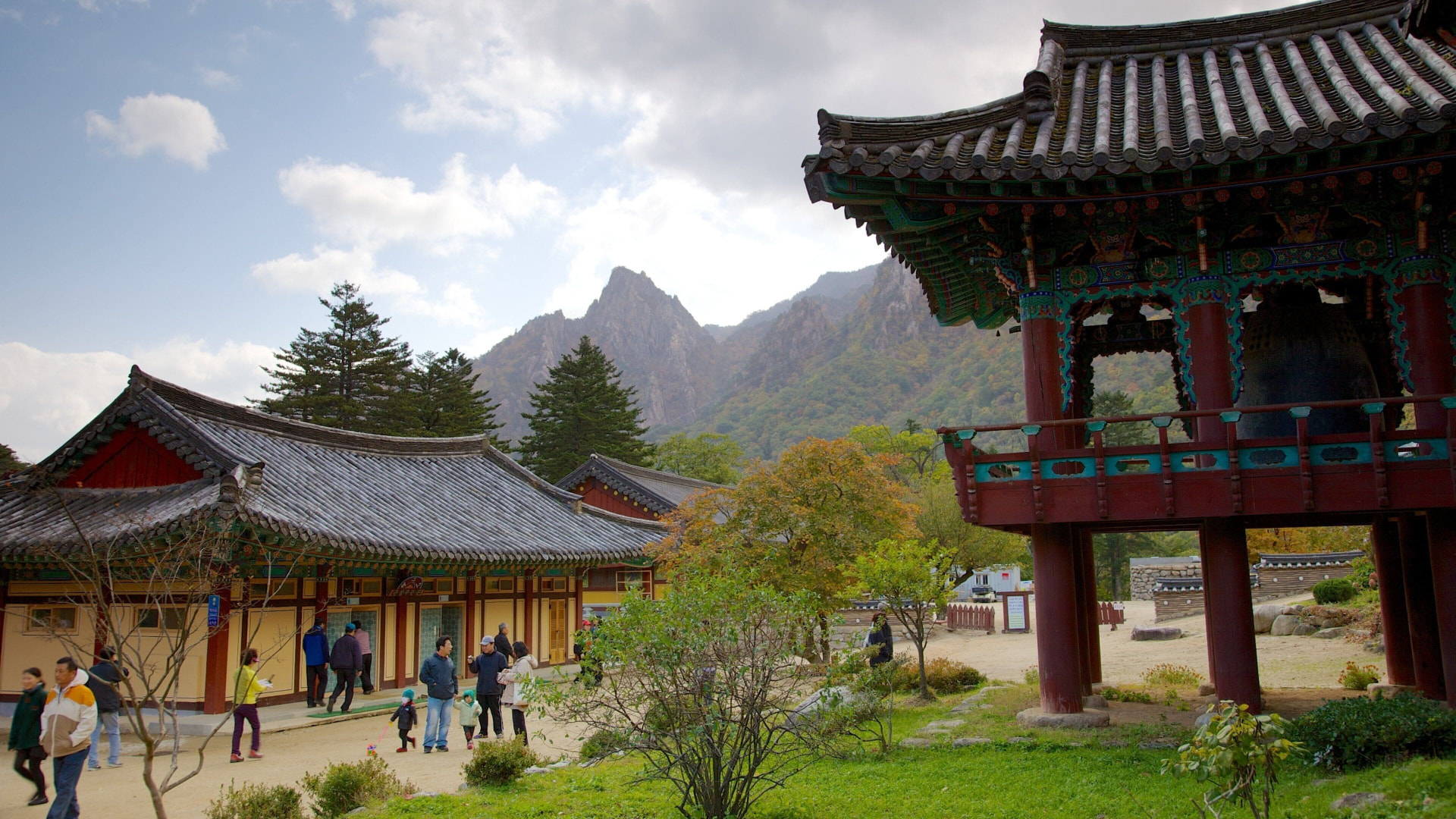 Sinheungsa Temple's bell pavilion and painted halls with Seoraksan's rocky peaks rising behind