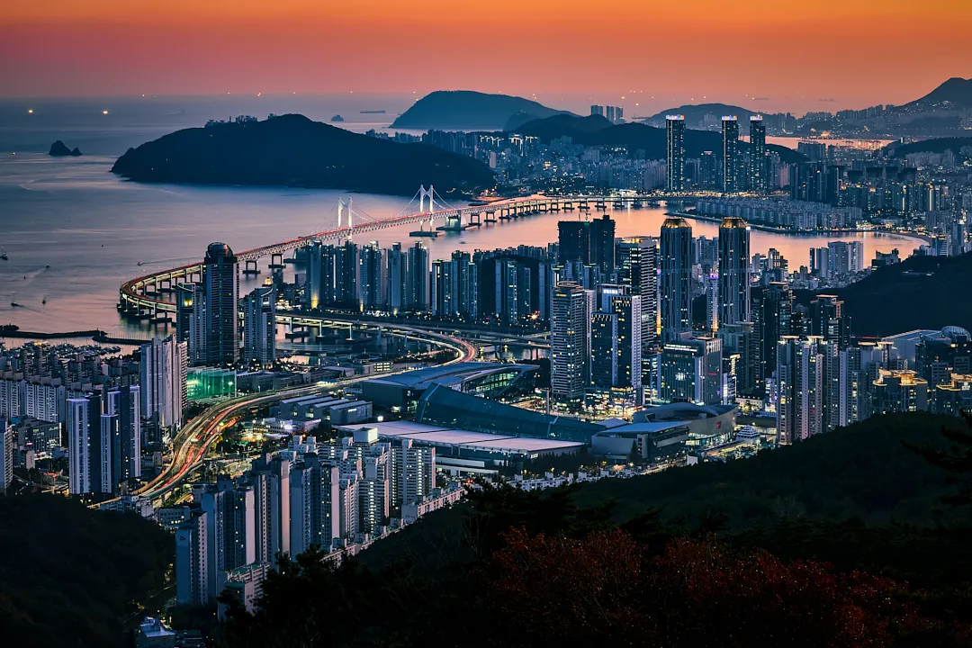 Gwangandaegyo Bridge and Busan skyline glowing at autumn dusk