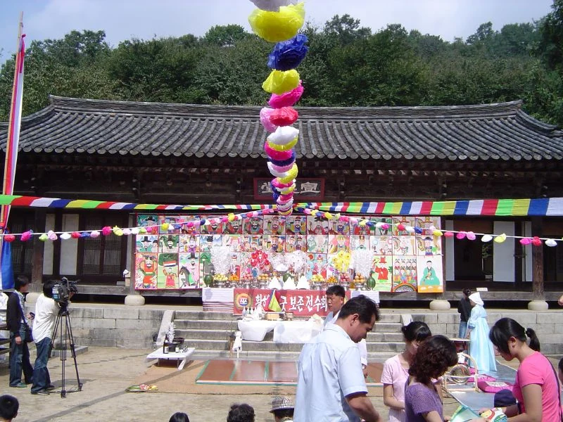 Visitors in a courtyard decorated with colourful lanterns and paintings