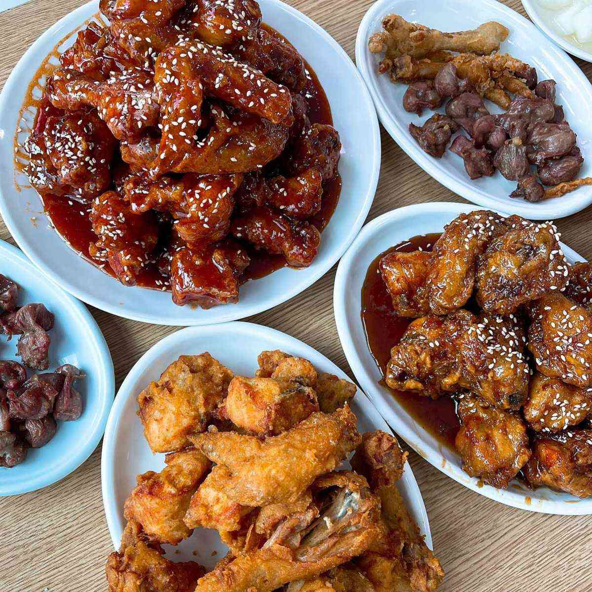 Plates of glossy Korean fried chicken and gizzards at Suwon's Tongdak street