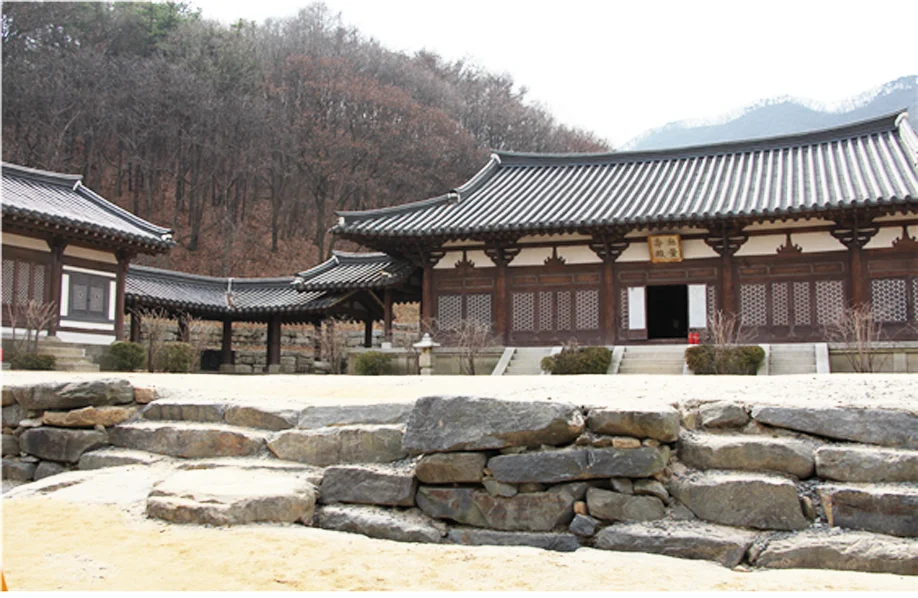 Tiled-roof palace buildings above rough stone terraces at MBC Dae Jang Geum Park