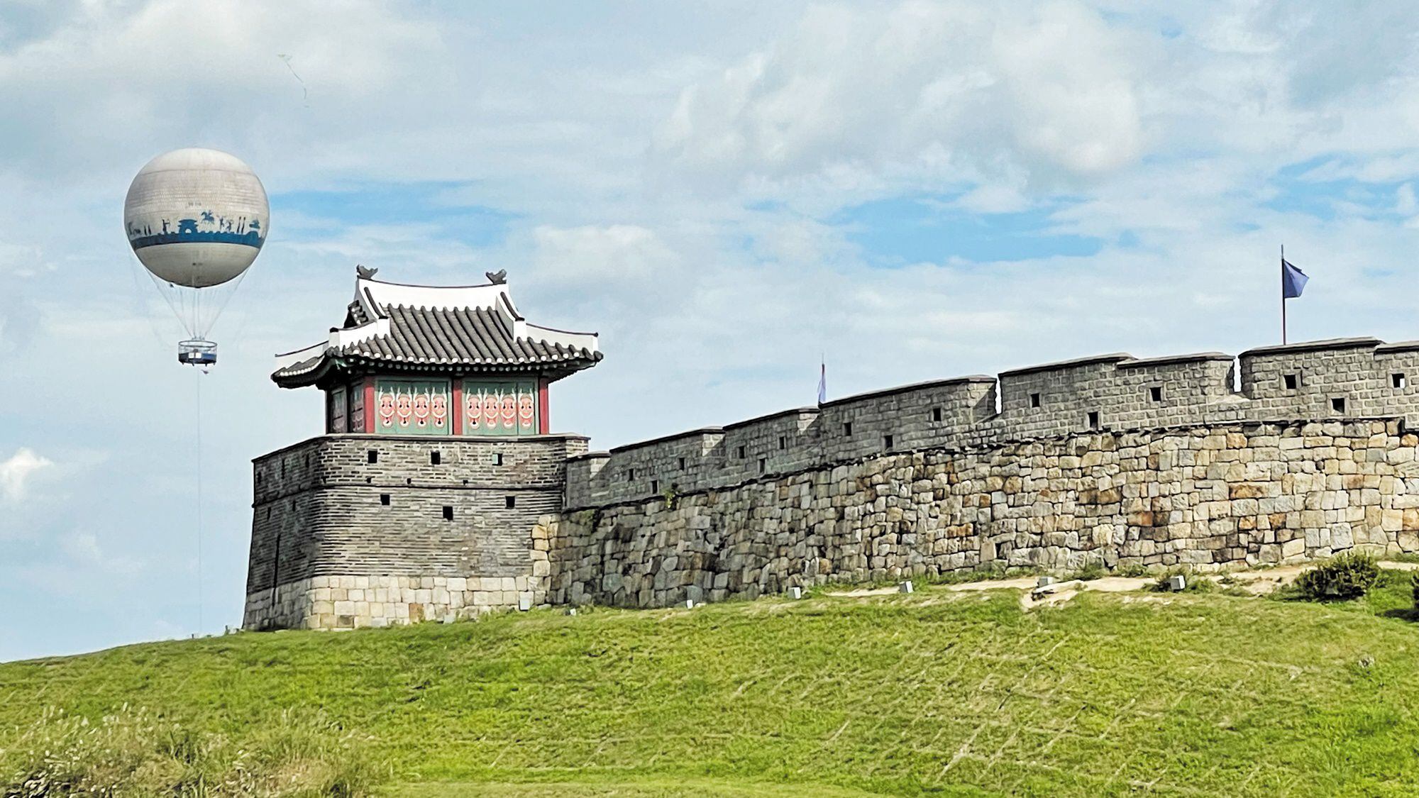 Hwaseong Fortress wall and gate with a hot air balloon in Suwon