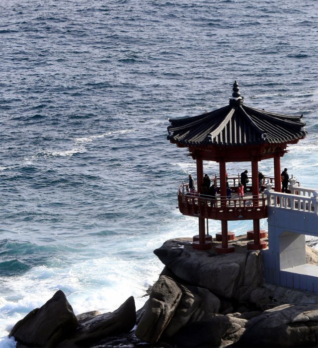 Traditional Korean pavilion standing on coastal rocks above waves on the East Sea