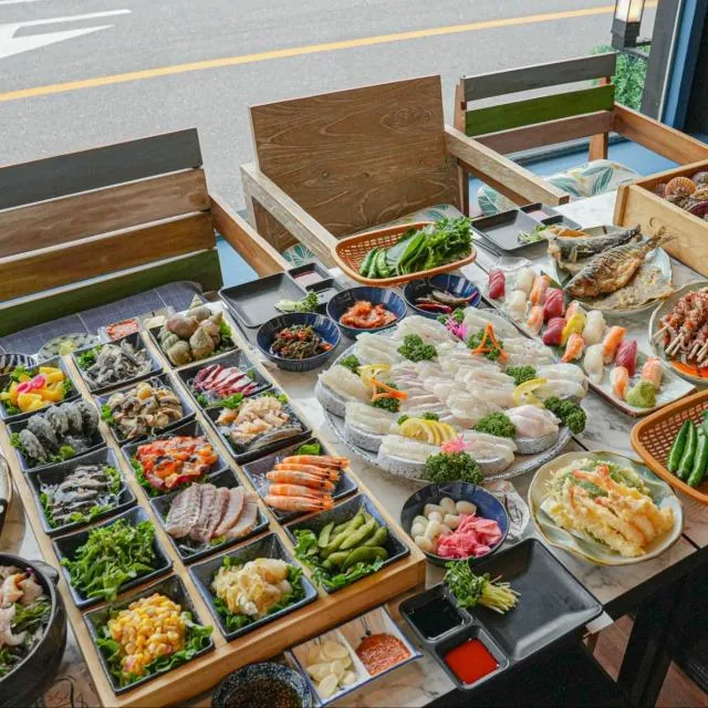 Mokpo seafood dinner spread with raw fish, shellfish and side dishes served on an outdoor table
